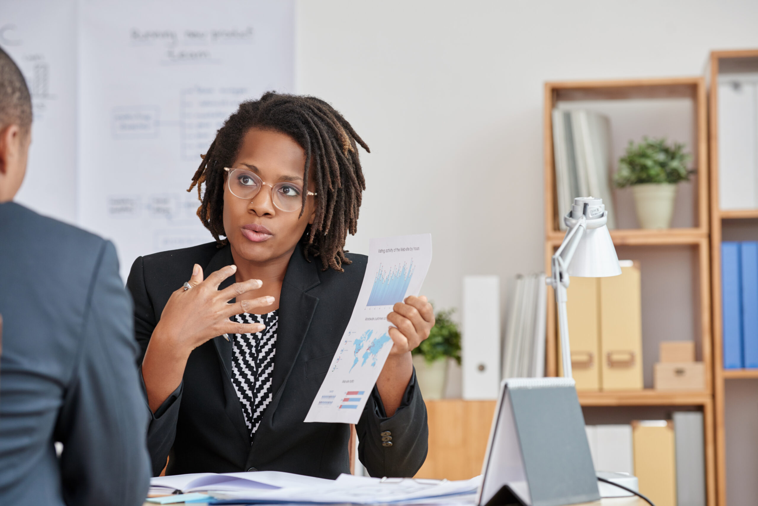 African-American business woman explaining results of her work to colleague